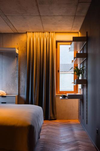a bedroom with a bed and a window at Hôtel Borsari, A Member of Design Hotels in Martigny-Ville