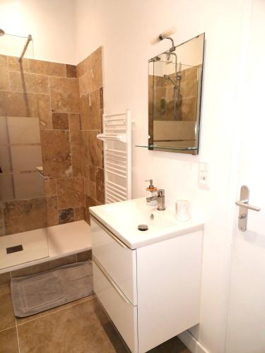 une salle de bain blanche avec un lavabo et une douche dans l'établissement Les Bons Enfants 2, à Rouen