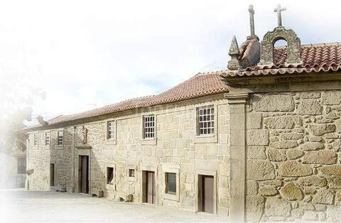 a stone building with a cross on top of it at CASA GRANDE DE JUNCAIS - SERRA DA ESTRELA in Fornos de Algodres