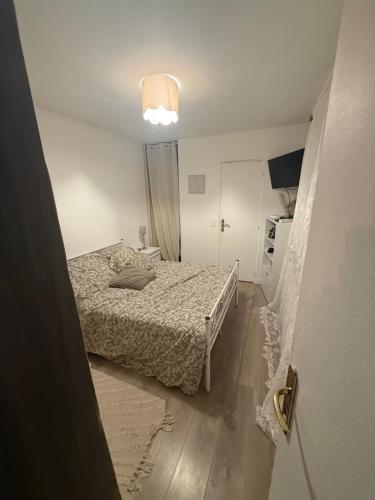 une chambre avec un lit et une lumière au plafond dans l'établissement Apparemment à 10 minutes de paris, à Alfortville
