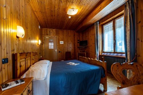 a bedroom with a bed in a wooden room at Hotel Le Campagnol in Champoluc