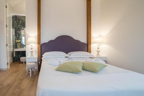a bedroom with a large bed with white sheets and pillows at Dimore Trulli Holiday in Alberobello
