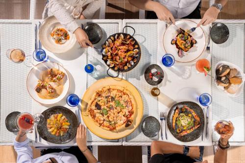 a group of people sitting around a table with food at Banyan Tree Tamouda Bay in Fnidek