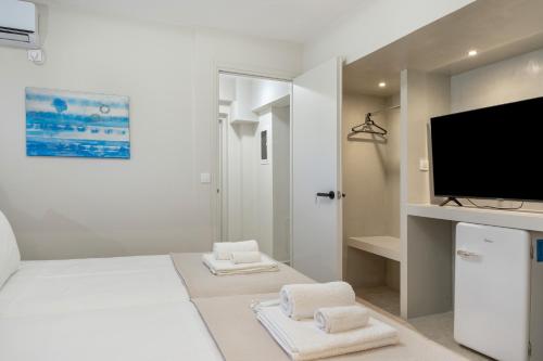 a white living room with a flat screen tv at Artemida Beach House in Artemida