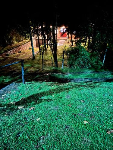 a field of grass with a fence and trees at Inti Huasi Raco in Siambón