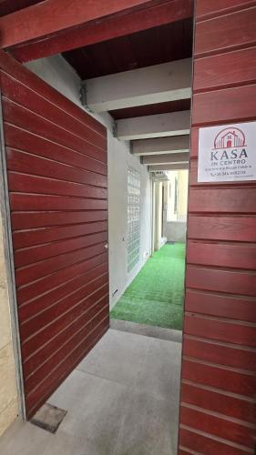 a red garage door of a building with a green lawn at Kasa in Centro INTERO APPARTAMENTO in Reggio Calabria