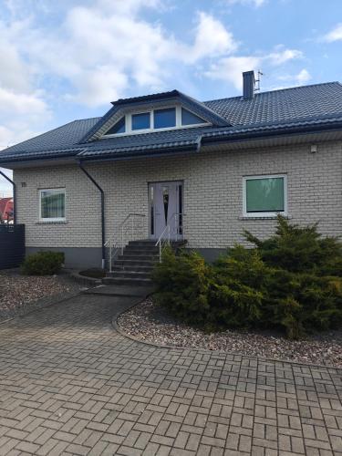 a house with a tile roof and a driveway at Vaido apartamentai in Marijampolė