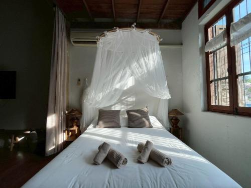 a bedroom with a white bed with two pillows on it at Yellow House in Bangkok