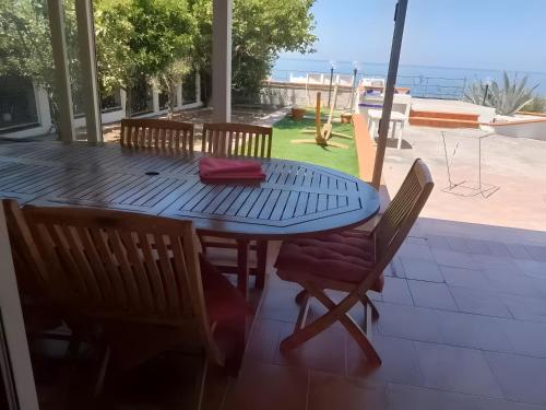 a blue table and chairs on a patio with the ocean at Casa Vista Mare con Giardino in Praia a Mare