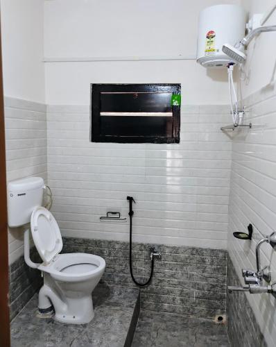 a bathroom with a toilet and a window at Globetrotters homestay in Jorhāt