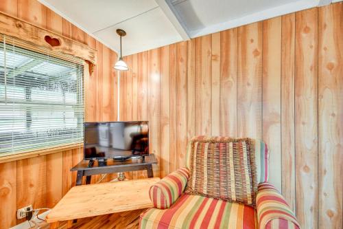 a living room with a chair and a television at Eufaula Retreat Community Pool and Screened Porch! in Eufaula