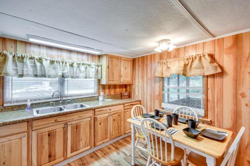 a kitchen with wooden cabinets and a table and chairs at Eufaula Retreat Community Pool and Screened Porch! in Eufaula