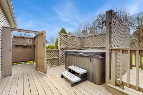 a large wooden deck with a grill and a fence at The Carriage House in Harwich