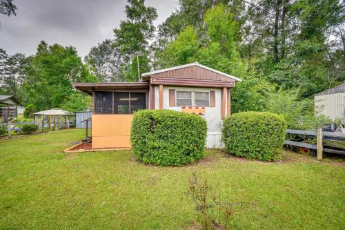 a tiny house in a yard with two bushes at Eufaula Retreat Community Pool and Screened Porch! in Eufaula