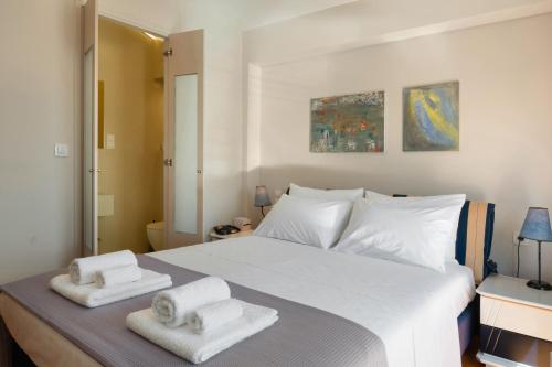 a bedroom with a large white bed with towels on it at Artemida Beach House in Artemida