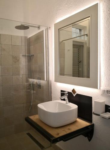 a bathroom with a sink and a shower with a mirror at Un'oasi tra i limoni in Naso