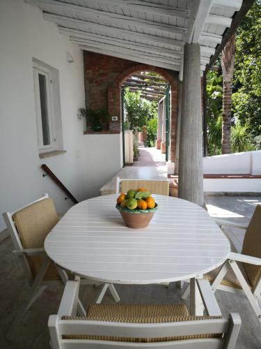 a bowl of fruit on a white table on a patio at Un'oasi tra i limoni in Naso