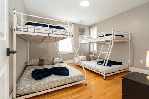 two bunk beds in a room with wooden floors at 558-1 Boston - Spacious & Modern 3BR near Franklin Park in Boston
