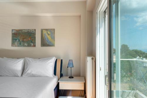 a bedroom with a bed and a window at Artemida Beach House in Artemida