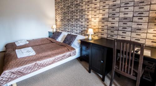 a bedroom with a bed and a wooden wall at Penzion Fojtstvi in Olomouc