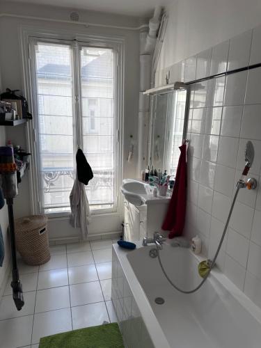 une salle de bain blanche avec une douche et un lavabo dans l'établissement Appartement muette, à Paris