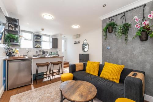 a living room with a couch and a table at The Cottage in Woolwich