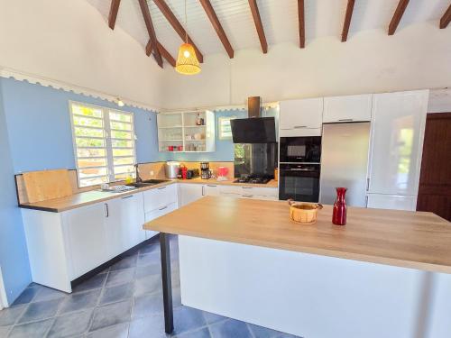 a kitchen with white cabinets and a wooden counter top at Villa Sol Y Sombra in Schœlcher