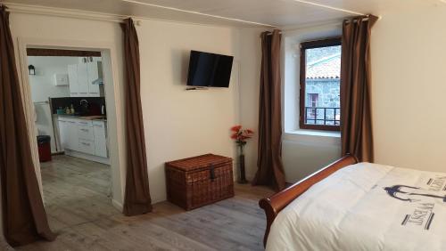 a bedroom with a bed and a window and a kitchen at Belle vue in Agde