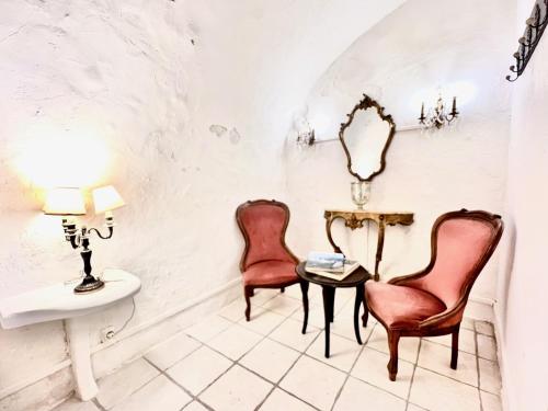 - deux chaises et une table dans une chambre avec lavabo dans l'établissement ApartHotel Riviera - Maison du Senat - Vieille Ville - Triplex 4 pièces à deux pas de la plage, à Nice