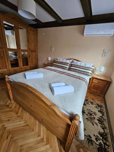 a bedroom with a large wooden bed with two towels at Kuca za odmor Poppke Danijela in Gradište Bekteško
