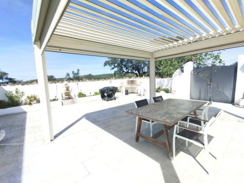 a patio with a table and chairs under a pergola at Quinta Azul in Loulé