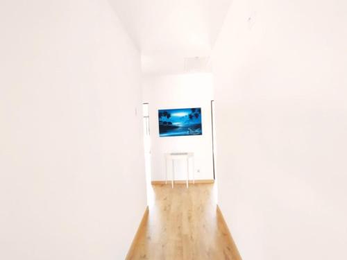 an empty room with a television in a white wall at Quinta Azul in Loulé