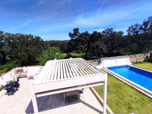 a view of a pool with a white roof and a swimming pool at Quinta Azul in Loulé
