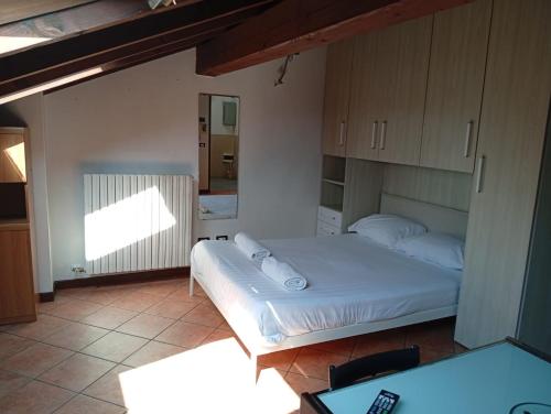 a bedroom with a bed and a desk and a television at la mansarda sul naviglio in Bellinzago Lombardo