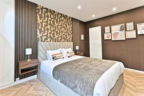 - une chambre avec un grand lit et un mur marron dans l'établissement Studio Élégant Paris - Père Lachaise, à Paris
