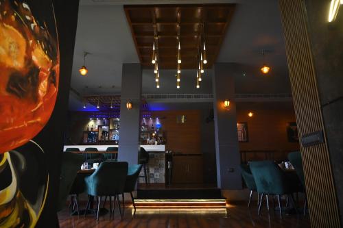 a bar in a restaurant with blue chairs at The Kannelite in Jamshedpur