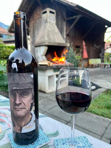 a bottle of wine next to a glass of red wine at KIENHOLZ by Stay in Brienz in Brienz