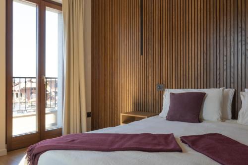 a bedroom with a large bed and a large window at Hotel Ristorante Da Politano in Boves