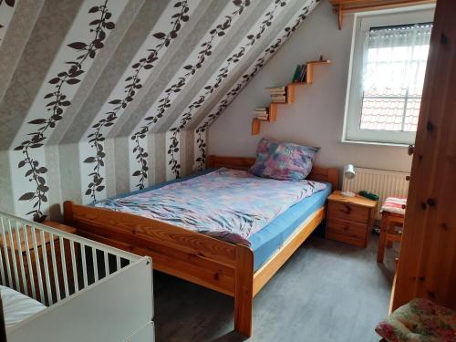 a small bedroom with a bed and a staircase at Ferienhaus vor den Toren Greetsiels in Krummhörn