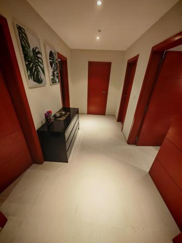 a hallway with red doors and white tile floors at MP's Residence 702 in Pointe-Noire