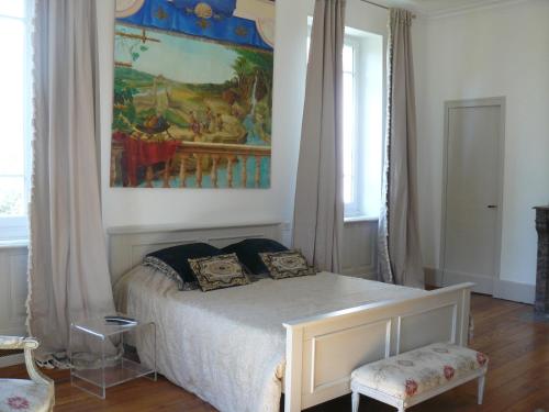 a bedroom with a bed and a painting on the wall at Villa Boulmia in Burlats