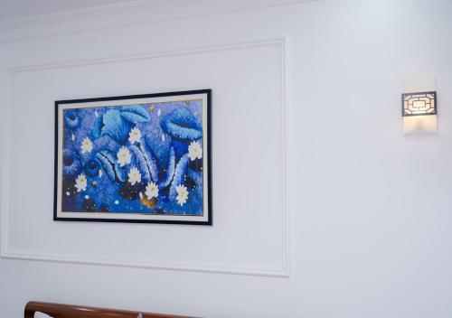 a painting hanging on a wall next to a lamp at Thiên Trang 3 Motel in An Khê