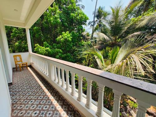 a balcony of a house with a view of palm trees at Studio Apartment jungle view 2minutes drive to the beach in Colva