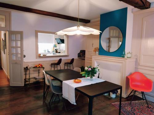 une salle à manger avec une table, des chaises et un miroir dans l'établissement Izabel Etxea, à Bayonne