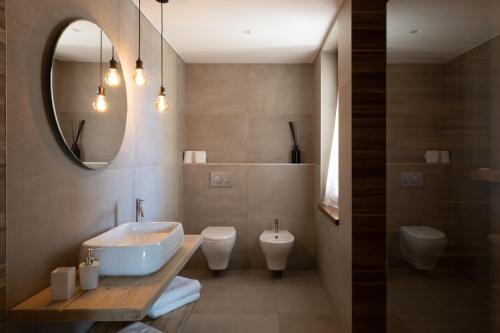 a bathroom with a sink and a toilet and a mirror at Hotel Ristorante Da Politano in Boves