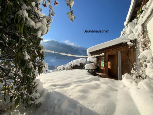 a snow covered path next to a house at Panoramachalet Tirolernaturschlaf in Wildschönau