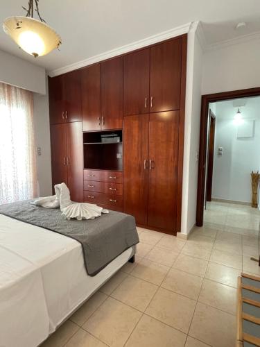 a bedroom with a bed and wooden cabinets at Kos Physis Apartment in Kos Town