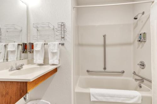 a white bathroom with a sink and a shower at Boulder Junction Motor Lodge in Boulder Junction