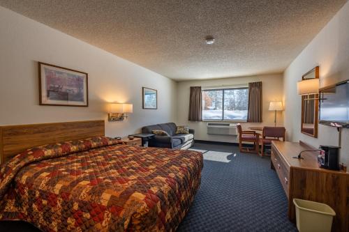 a hotel room with a bed and a desk at Boulder Junction Motor Lodge in Boulder Junction