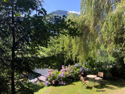 a garden with a table and chairs and flowers at Panoramachalet Tirolernaturschlaf in Wildschönau